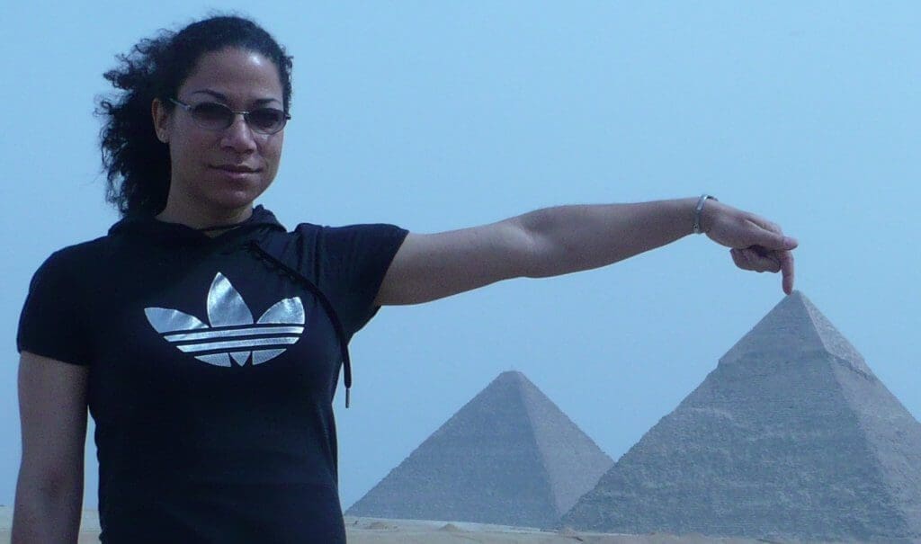 Picture of a woman posing in front of the pyramids in Cairo, Egypt.