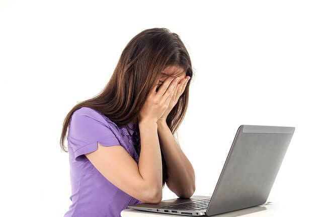 An image of a woman leaning on her laptop