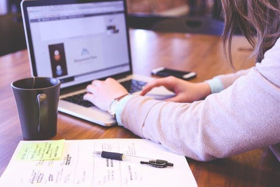 An image of a woman looking at a laptop.