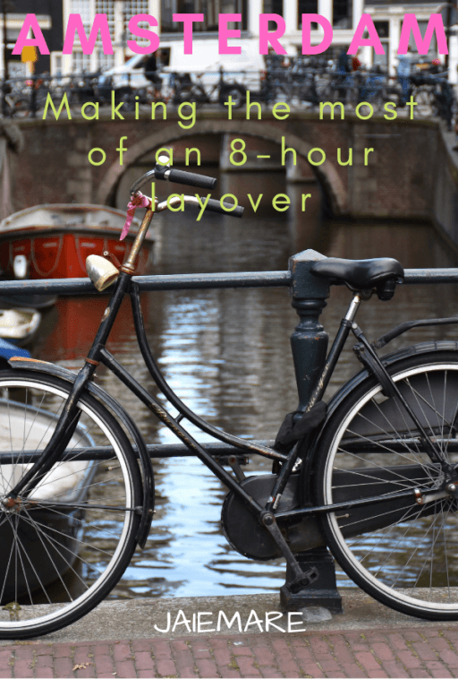 Bike sitting in front of a boat canal in Amsterdam.