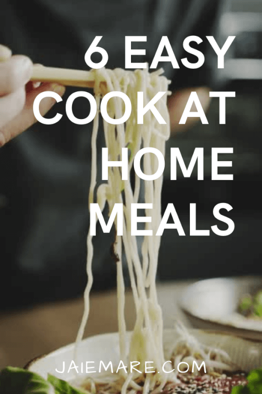 An individuals lifting noodles from a bowl with chopsticks