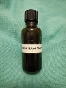 Bottle of walnut and ylang ylang scalp massage oil.